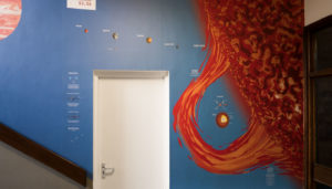 Science school wall graphic showing a sun flare and the inner solar system