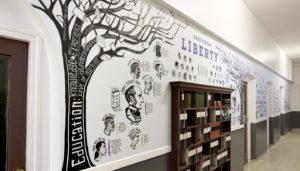 School wall graphics - British Values wall - showing Education Tree of words with a bookcase set into the wall - hand illustrated wall design by Toop Studio